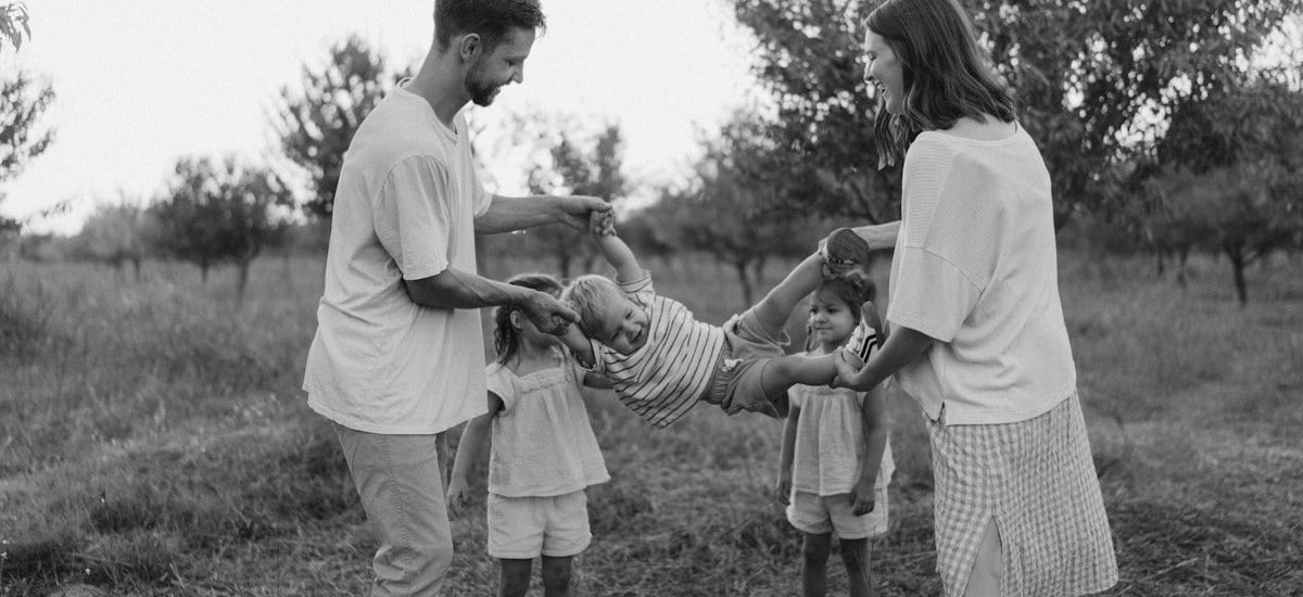 Family playing with child in grassy field