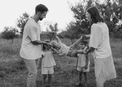 Family playing with child in grassy field